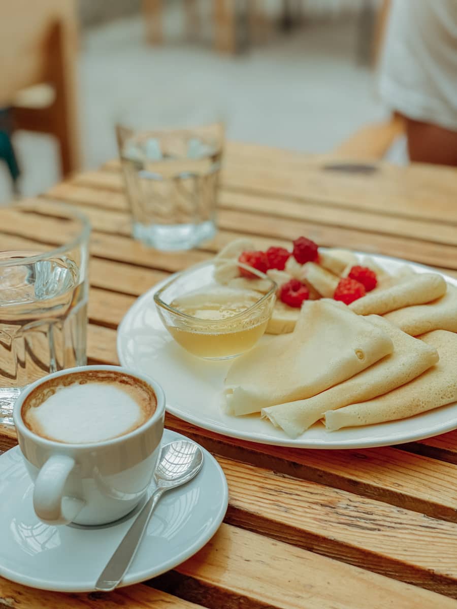 Café con tortitas junto con 2 vasos de agua en Karakol, Kirguistán.