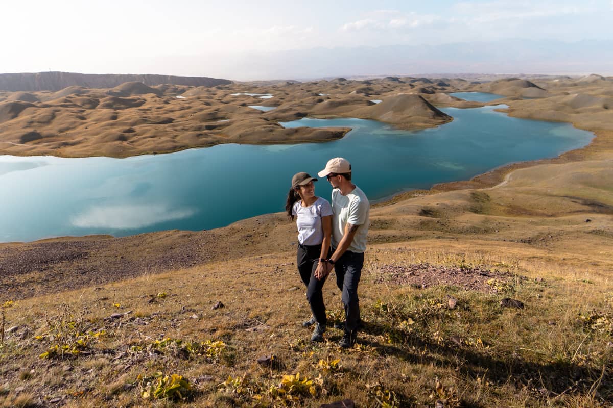 Pareja posando y cogidos en la cima de Tulpar Kul, al sur de Kirguistán con los lagos de fondo