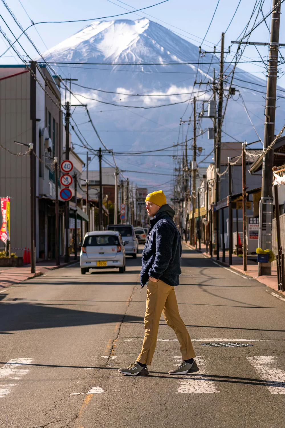 Chico cruzando Honcho Street con el Monte Fuji de fondo, en Fujiyoshida, Japón.