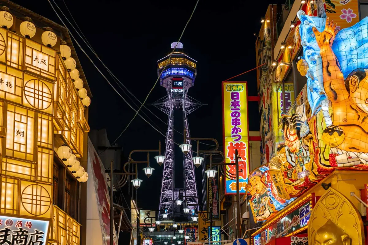 Torre de Osaka y calle iluminada por figuras y carteles en relieve