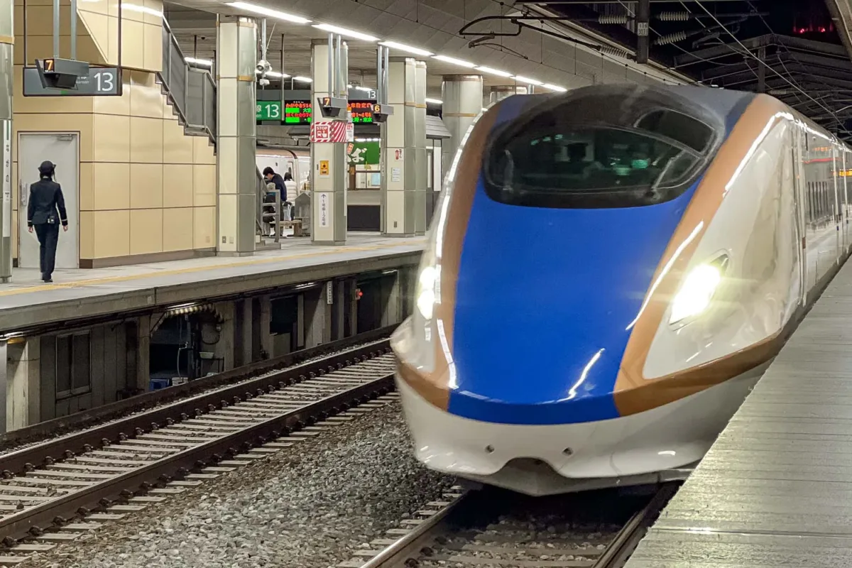 Tren bala (Shinkansen) de Japón llegando por la vía en la estación.