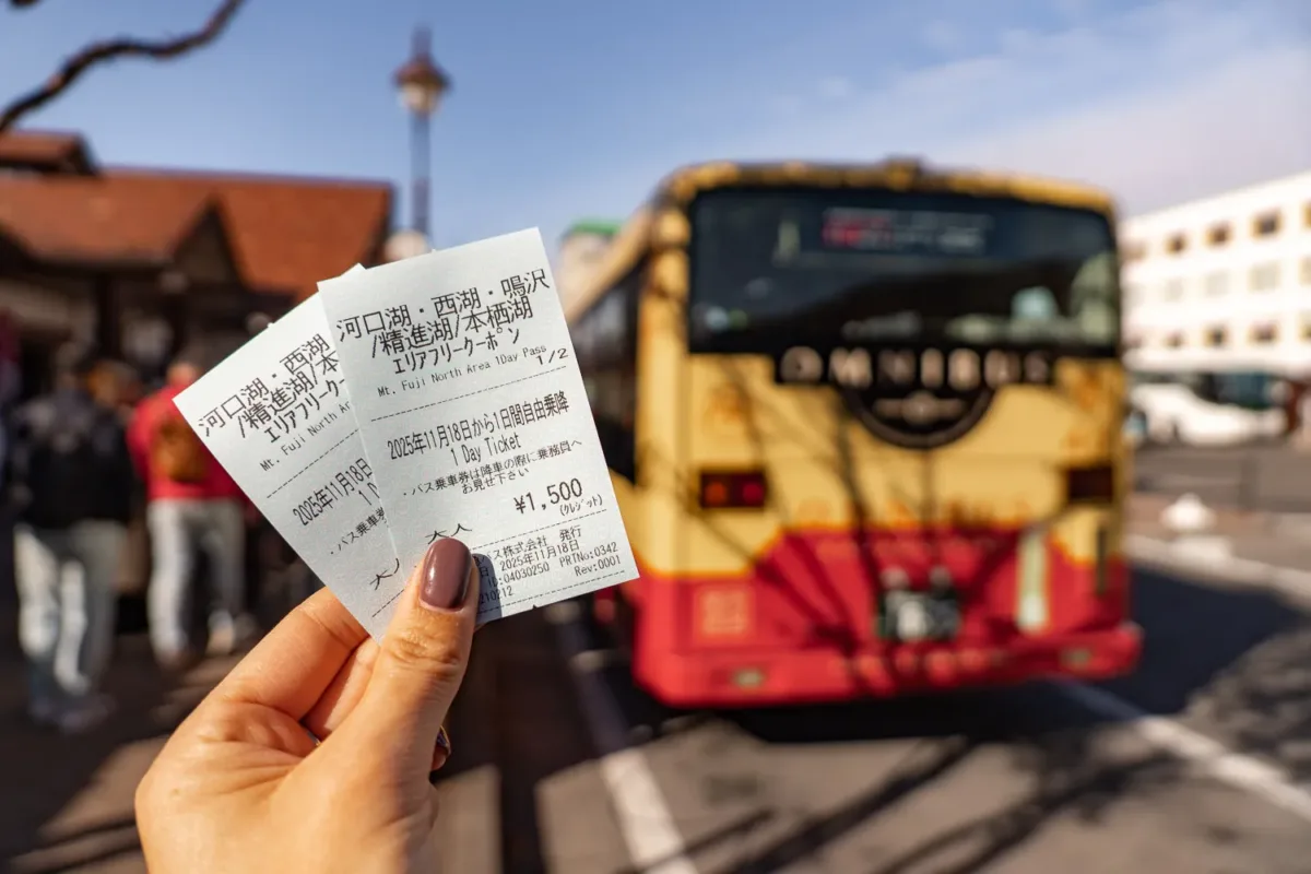 Billetes de autobús en Japón con transporte público de fondo.
