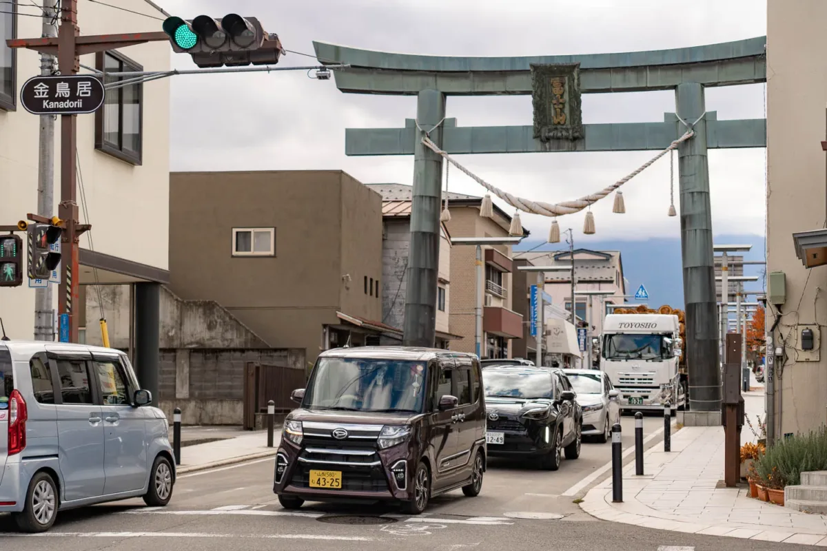 Calle en Japón con torii y tráfico urbano, ejemplo de cómo moverse en Japón por ciudad.