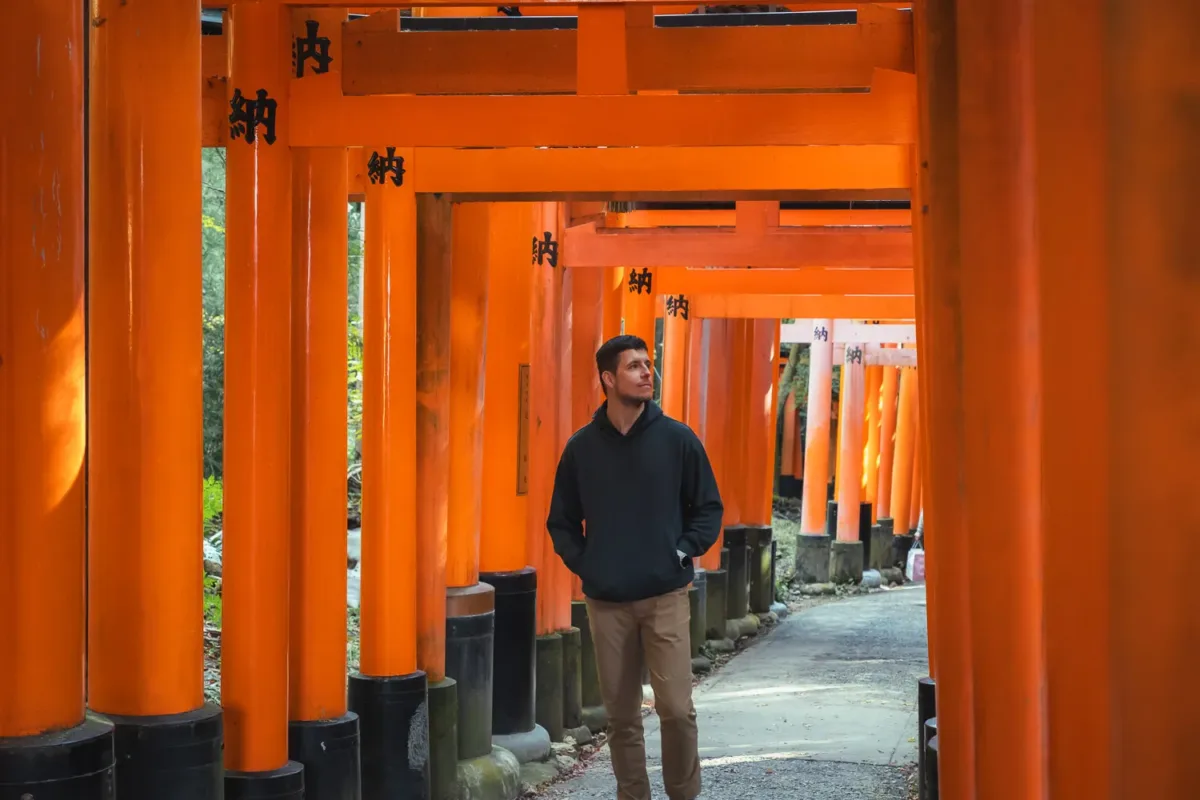 chico paseando entre los torii rojos de Fushimi Inari en Kioto