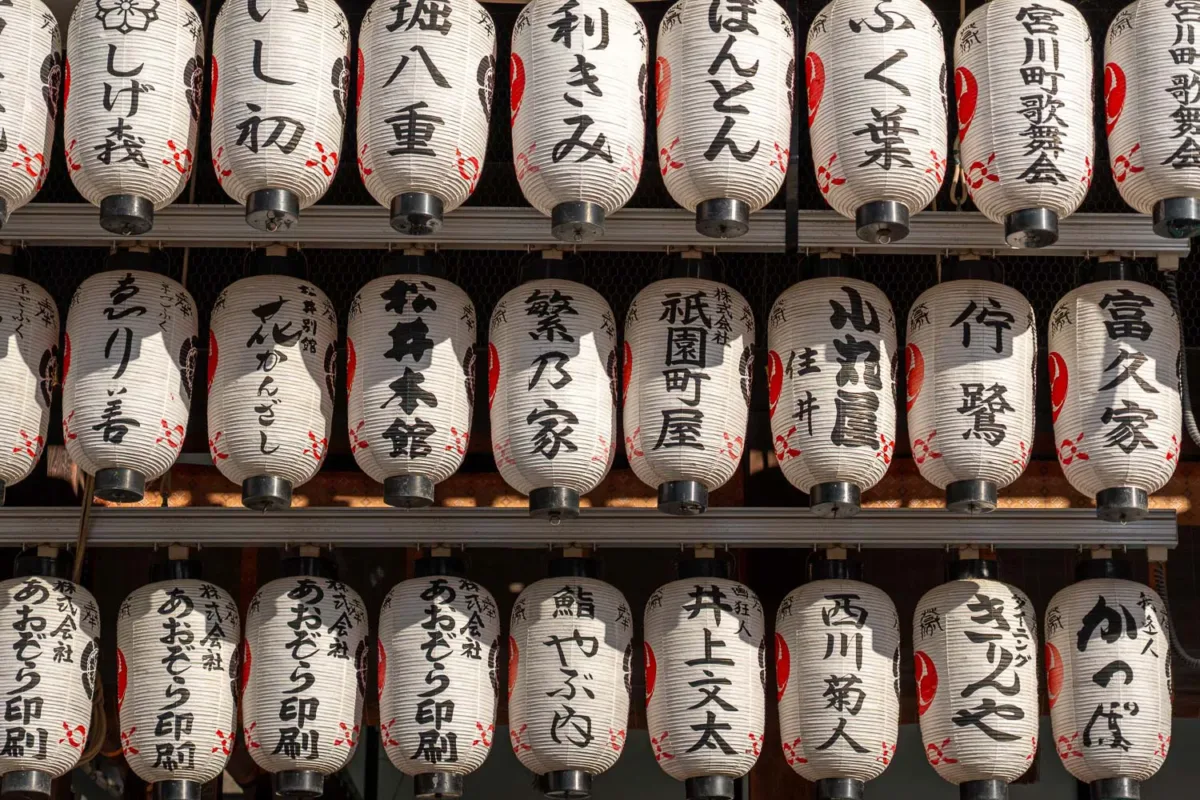 Farolillos colgando con inscripciones en japonés en el templo de Yasaka en Kioto