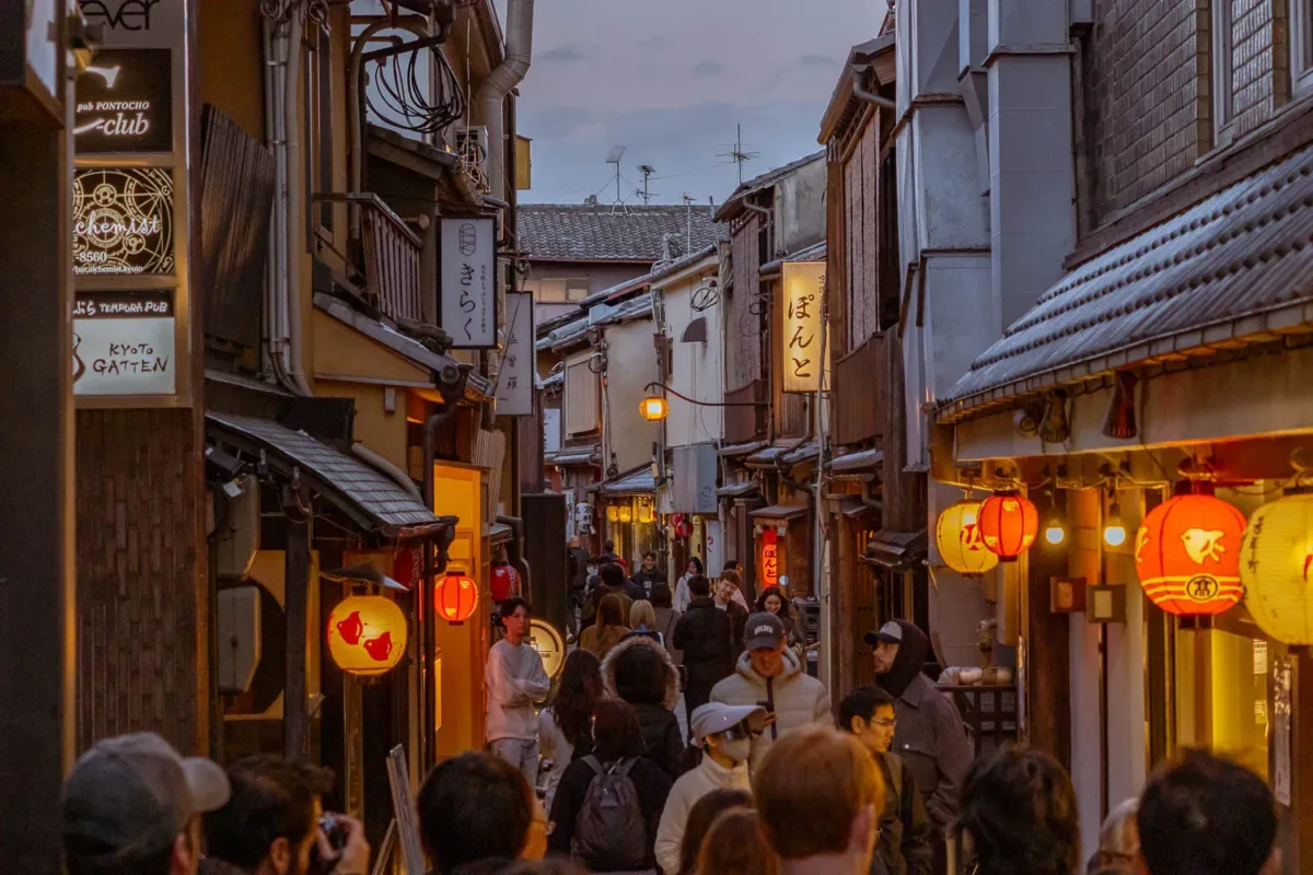 Callejón Pontocho al anochecer un sitio que ver en Kioto con mucha gente y farillos iluminados en las puertas de restaurantes