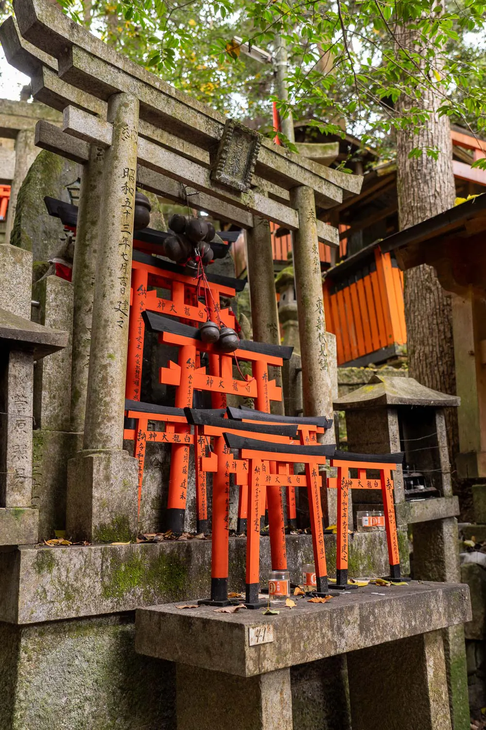Altar con figuras de torii en piedra y madera de diferentes tamaños en templo Fushimi Inari
