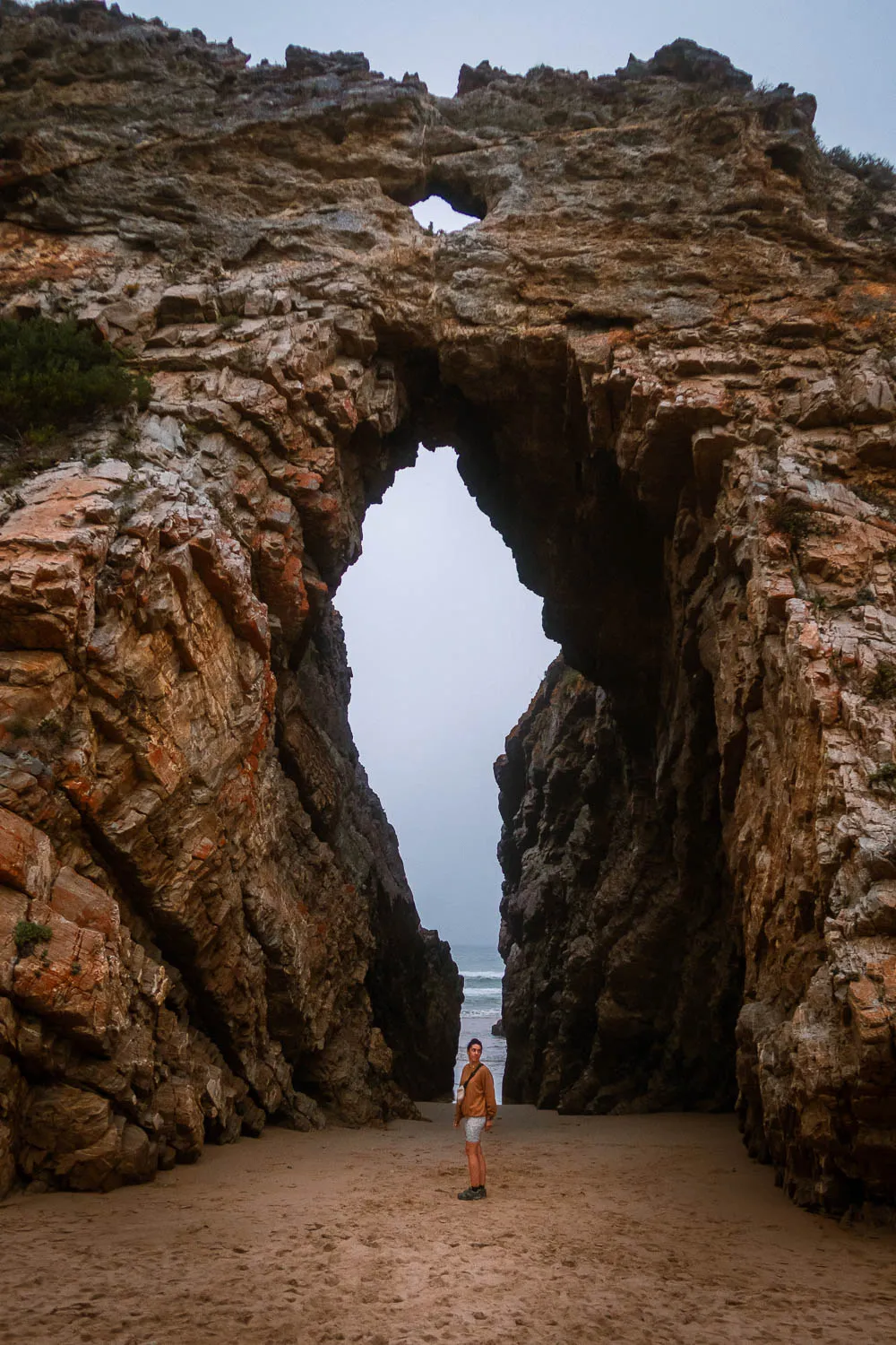 Chica en frente de la roca enorme de Cathedral Rock, en la Garden Route de Sudáfrica.