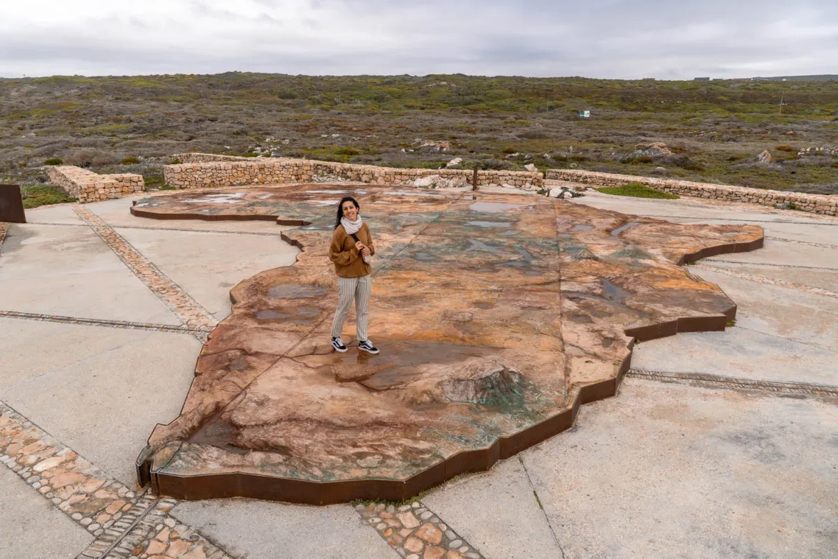 Chica encima de una representación del mapa de África, en Cabo Agujas, Sudáfrica.