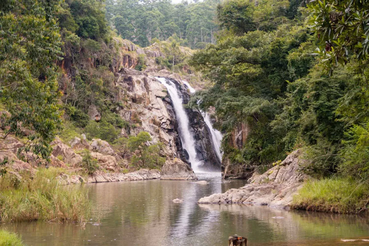 Paisaje verde, con una cascada al fondo y envuelto por vegetación en Esuatini.