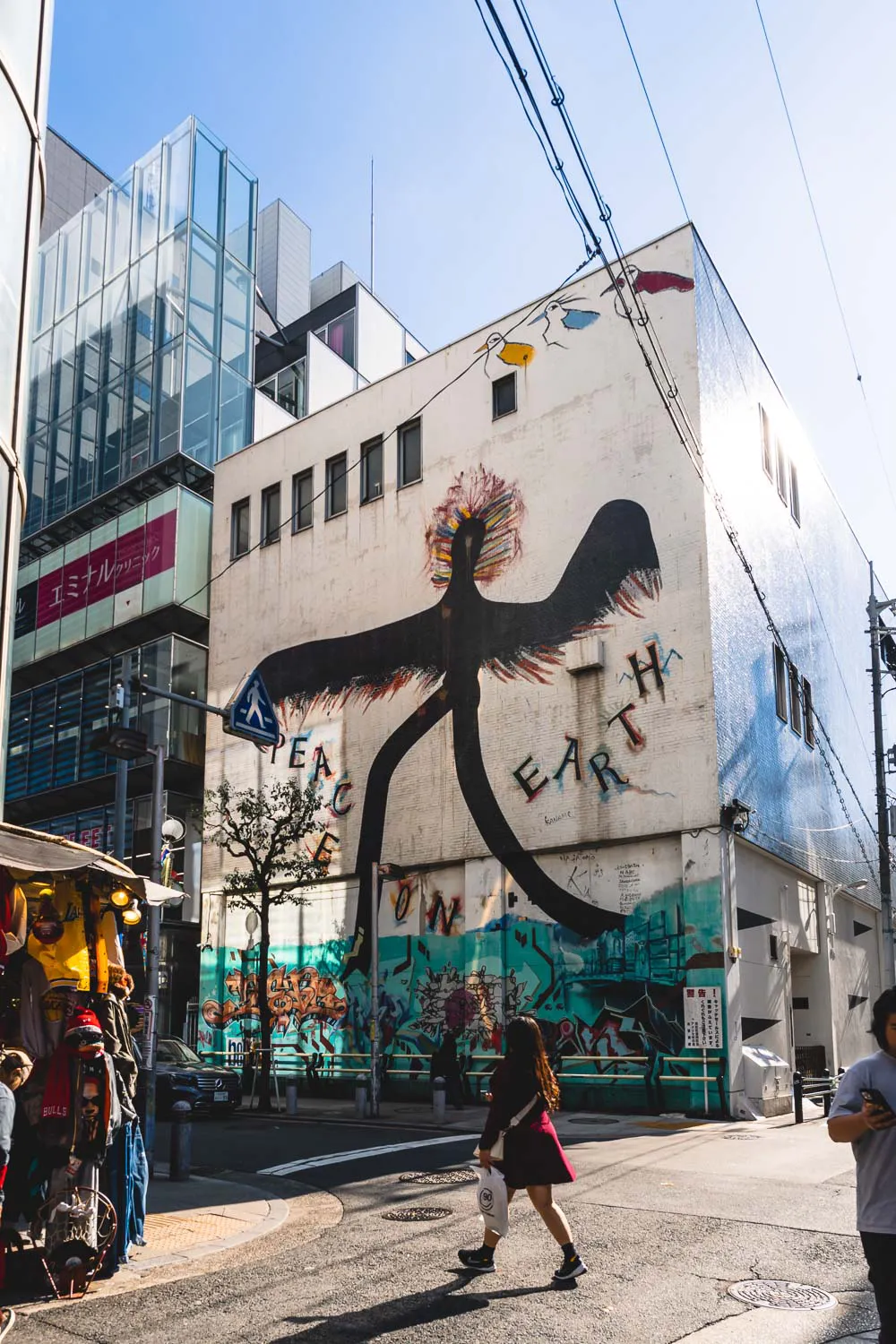 Mura con graffitti PEace on Earth en barrio Amerikamura en Osaka