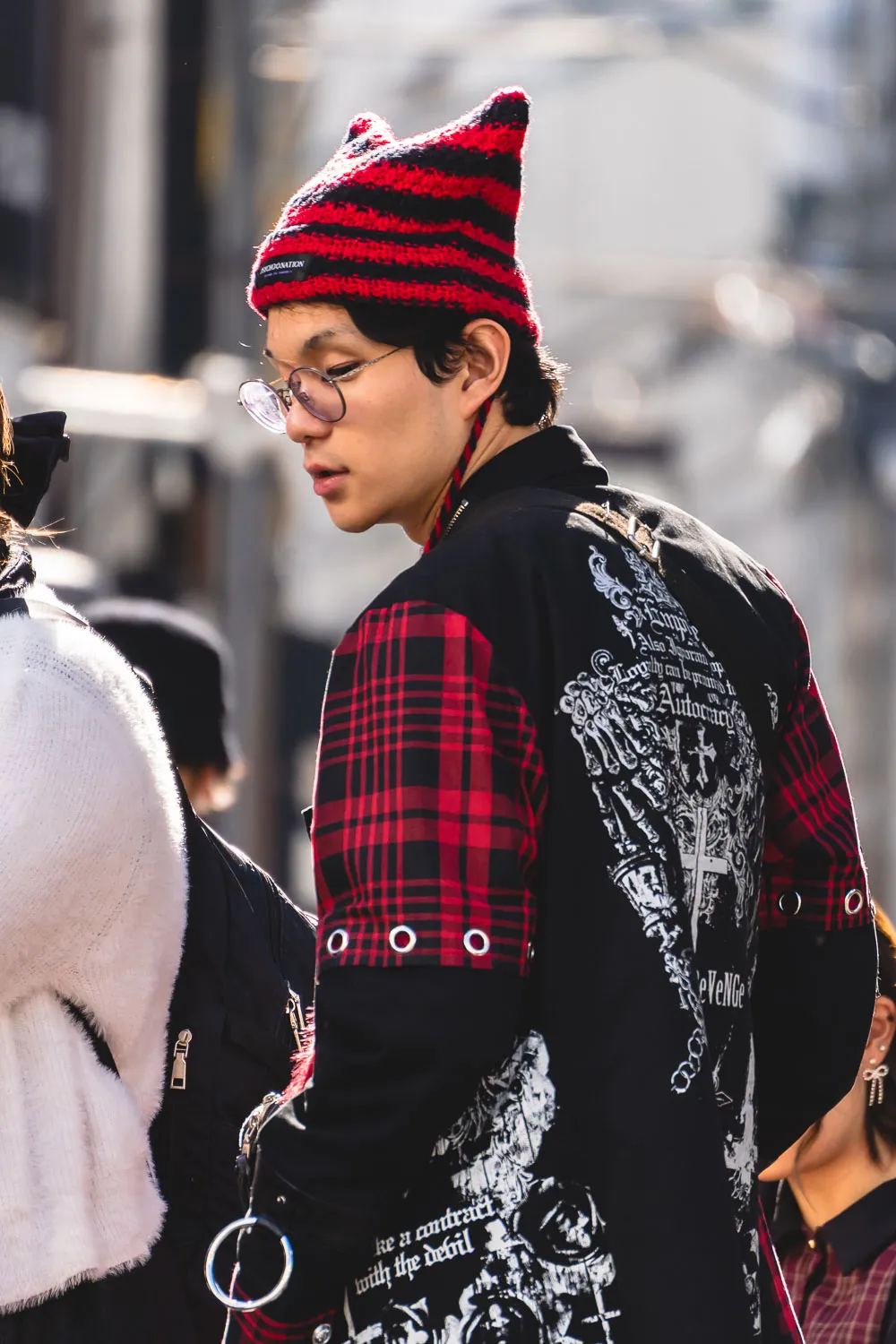 Chico japonés con un look curioso paseando por la calle en Amerikamura en Osaka.