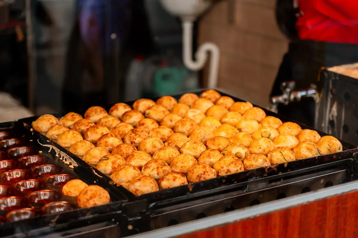 plancha con bolas de takoyakis ya dorados acabado de cocinarse