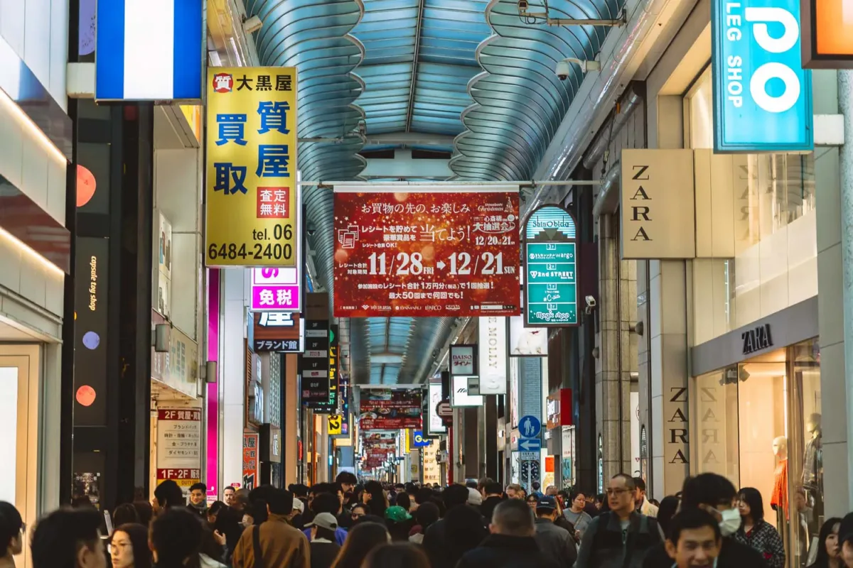 Calle comercial Shinsaibashi cubierta y llena de gente y tiendas a ambos lados para comprar en Osaka.