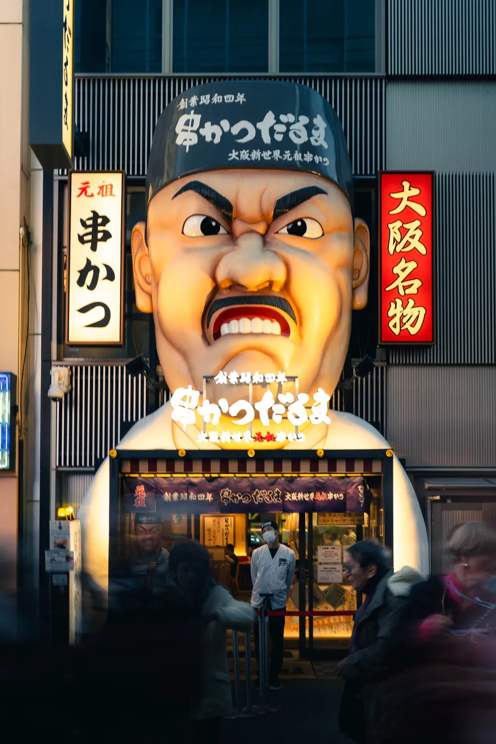 Fachada de restaurante en relieve con figura de chef y expresión enfadada.
