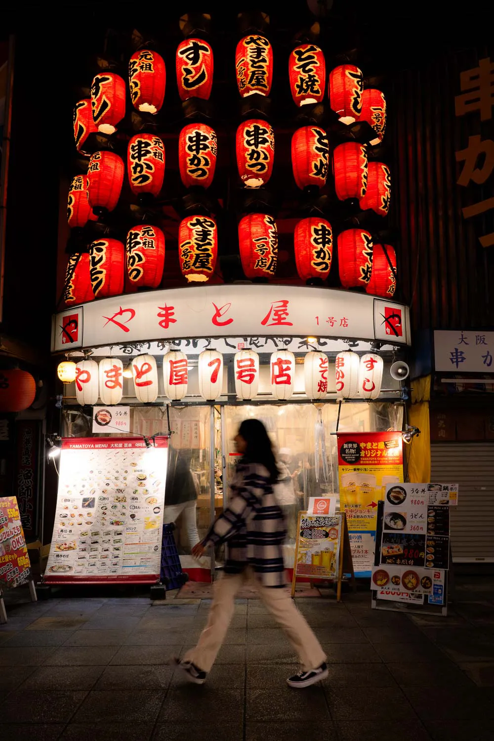 farolillos rojos iluminados en la fachada de un restaurante en shinshekai en Osaka